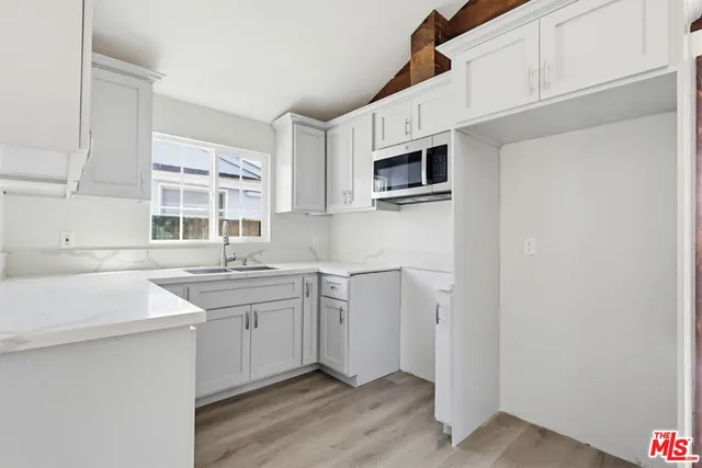 a kitchen with a sink cabinets and wooden floor