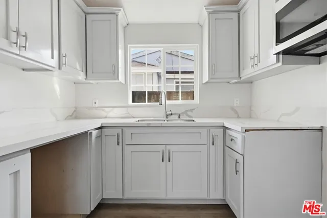 a kitchen with stainless steel appliances granite countertop a sink and dishwasher with white cabinets