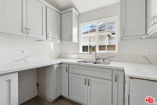 a kitchen with stainless steel appliances granite countertop a sink dishwasher and cabinets with wooden floor