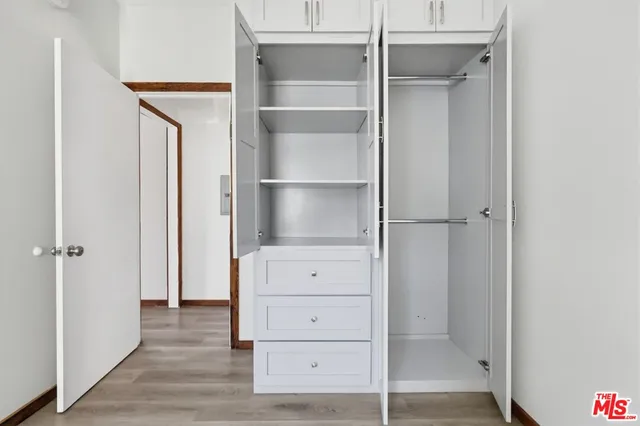 a view of walk in closet with empty racks