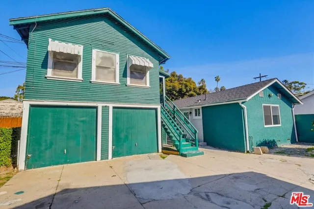 a front view of a house with a yard and potted plants