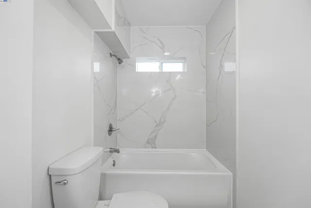 a bathroom with a shower a toilet and a window