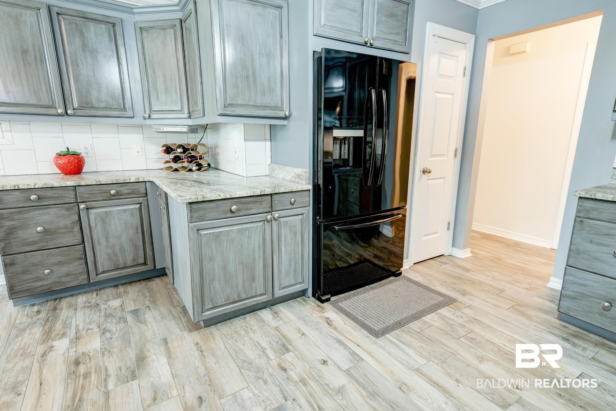10093 Willis Road Foley, AL 36535 - Photo 20 of 33 Kitchen featuring black refrigerator with ice dispenser, tasteful backsplash, light stone counters, and light wood finished floors