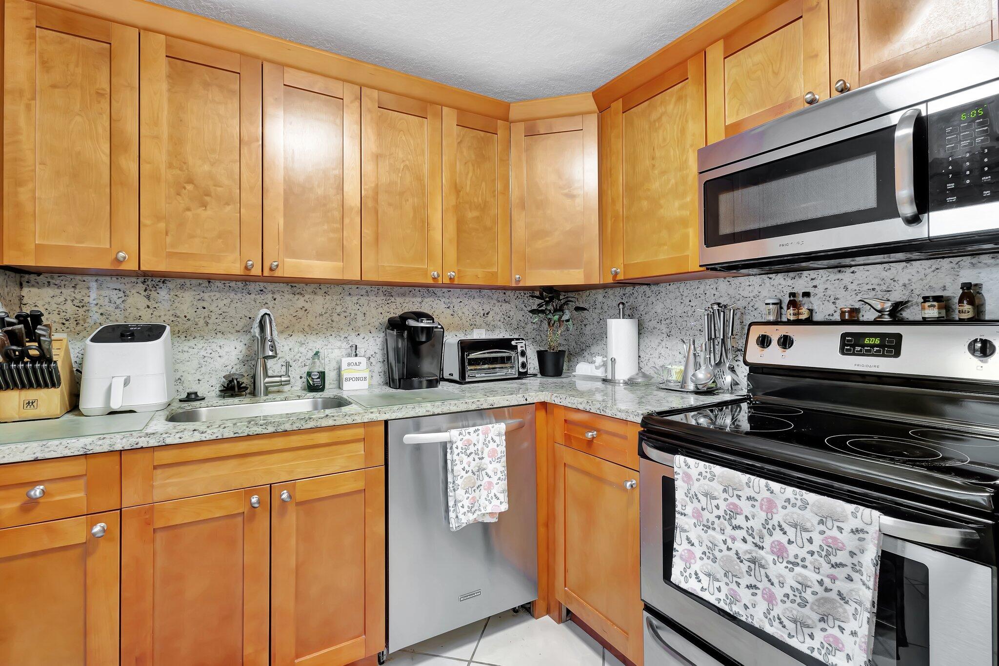 637 Monaco Court, Unit 637 Delray Beach, FL 33446 - Photo 1 of 58 a kitchen with stainless steel appliances granite countertop a stove a sink dishwasher and cabinets with wooden floor