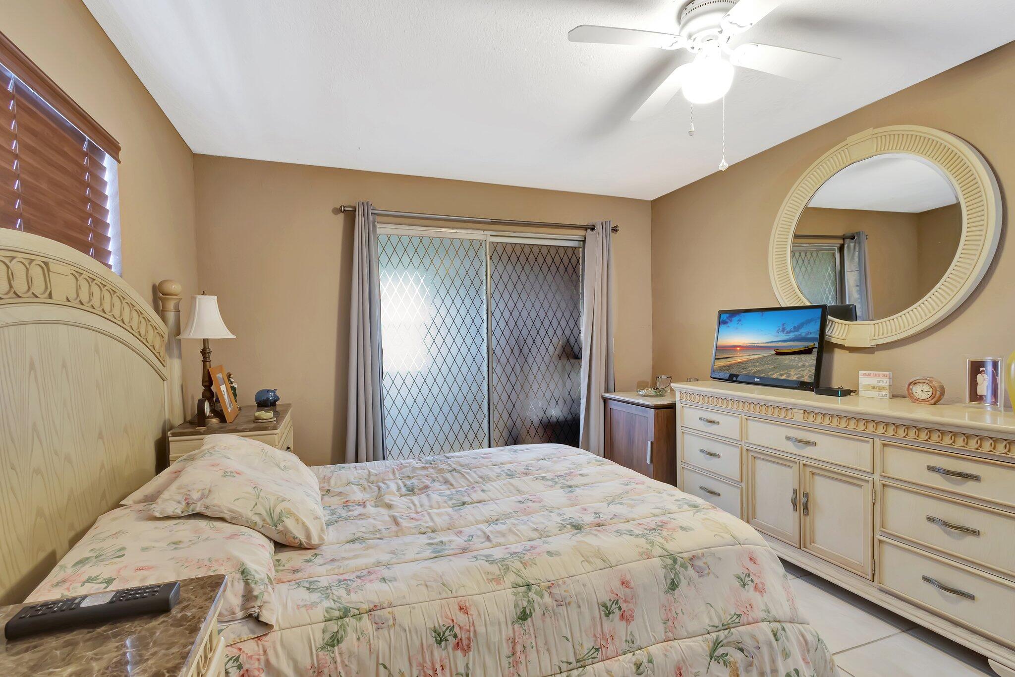 637 Monaco Court, Unit 637 Delray Beach, FL 33446 - Photo 17 of 58 a bedroom with a large bed and a chandelier