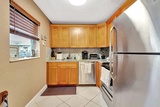 a kitchen with stainless steel appliances a refrigerator sink and cabinets