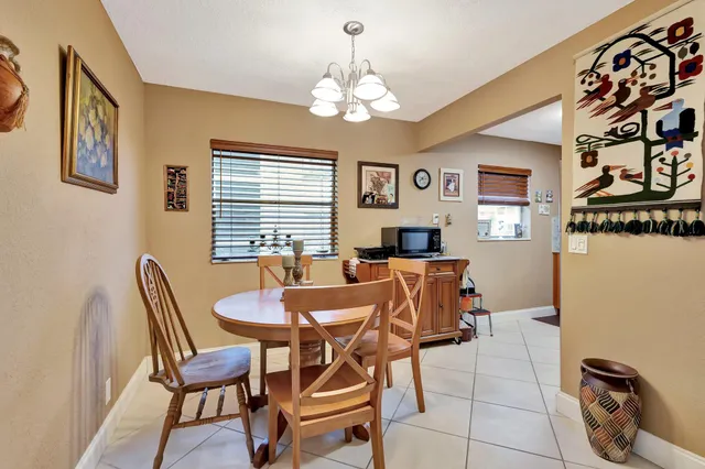a dining room with chandelier and wooden floor