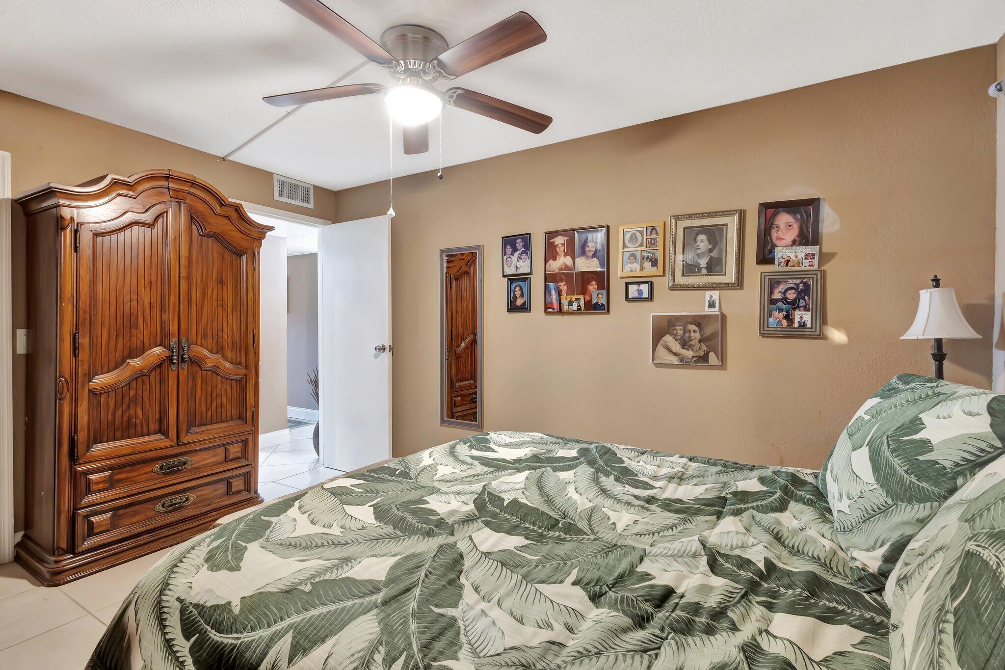 637 Monaco Court, Unit 637 Delray Beach, FL 33446 - Photo 10 of 58 a bedroom with a large bed and a chandelier