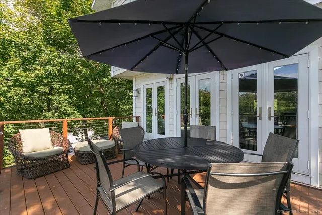 a patio with wooden floor a yard a table and chairs