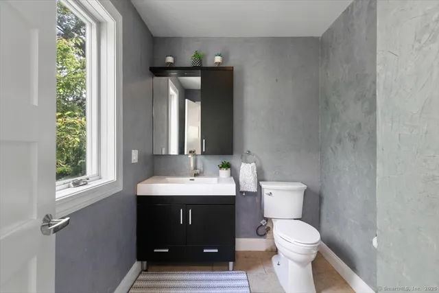 a bathroom with a toilet sink and mirror