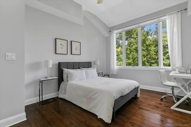 a bedroom with a bed and a table in it with window
