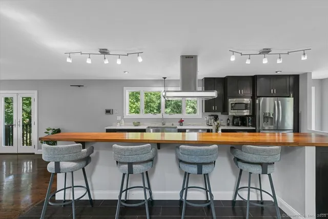 a kitchen with stainless steel appliances granite countertop a sink and chairs