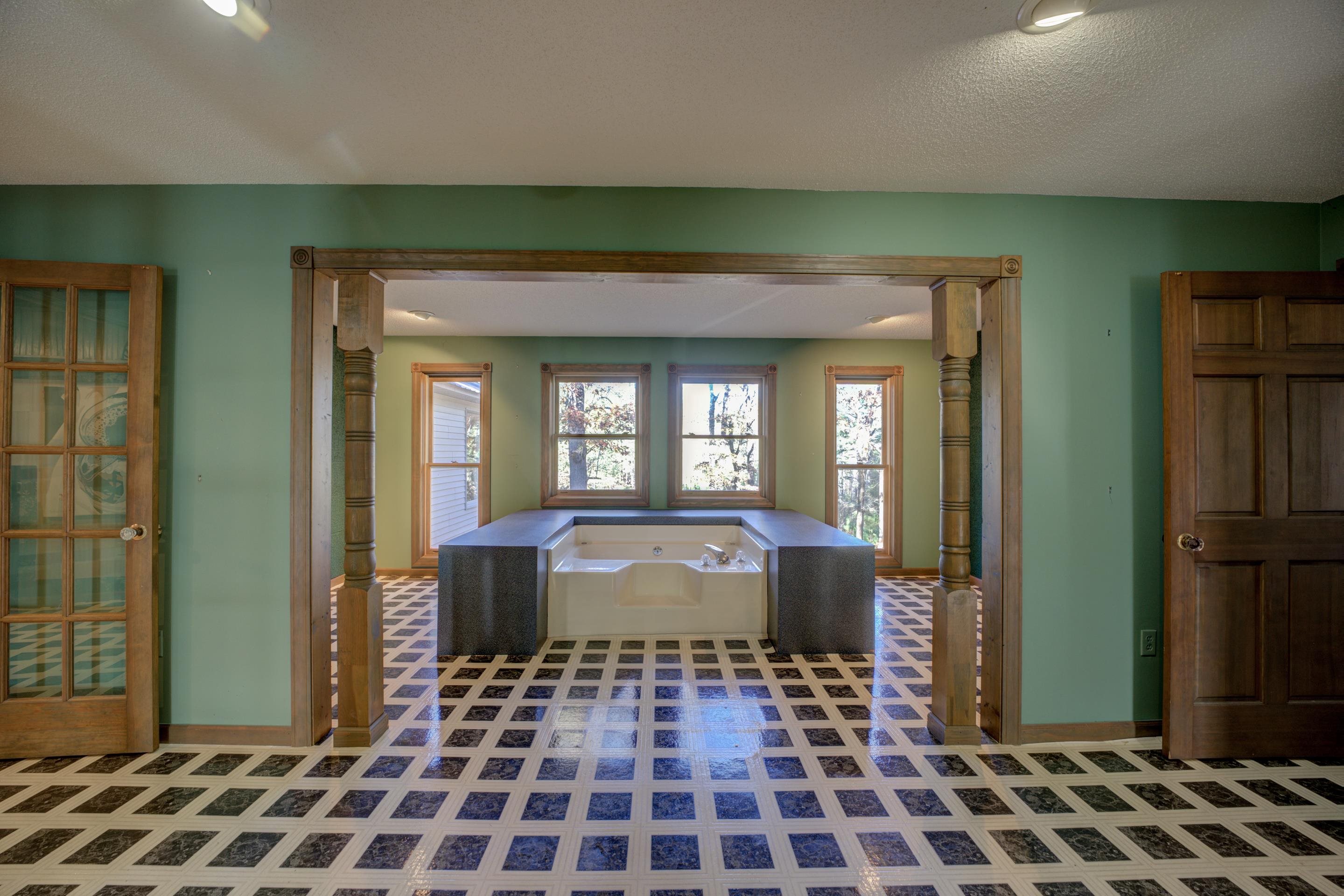 183 Matlock Road Ramer, TN 38367 - Photo 30 of 34 a living room with a black white checkered floor with a chandelier and fireplace