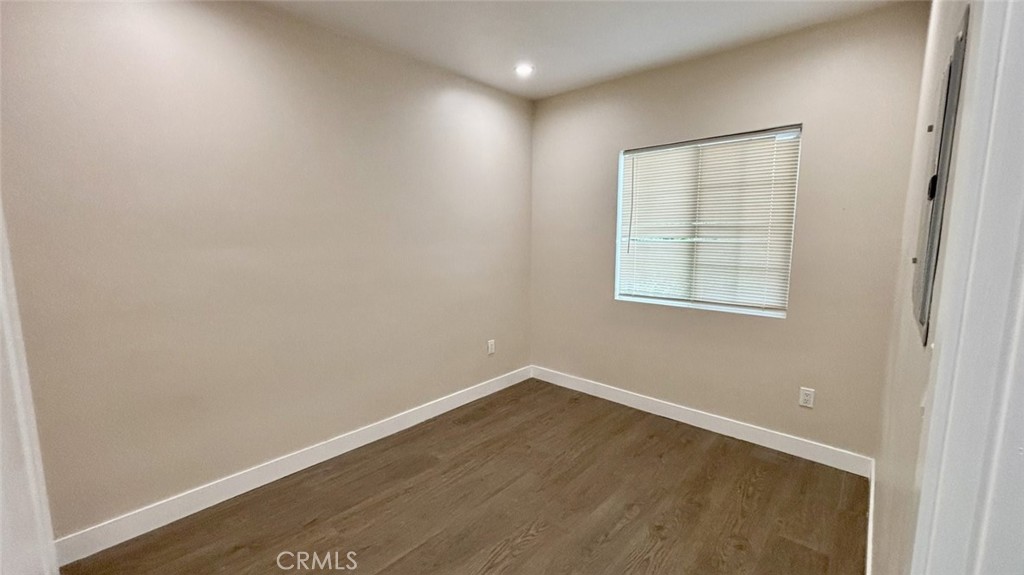 9981 Stanwin Avenue Arleta, CA 91331 - Photo 4 of 6 an empty room with wooden floor and windows