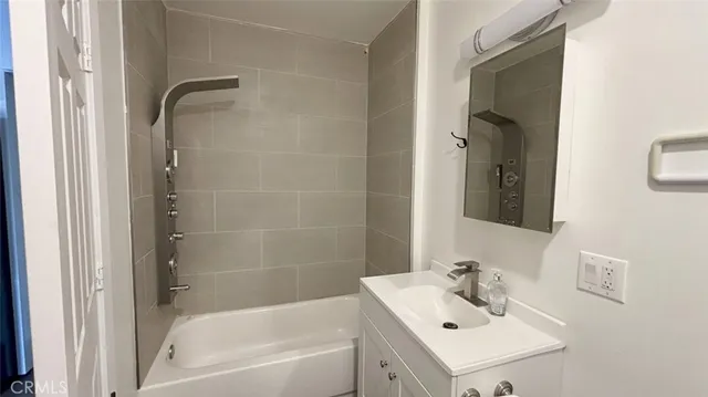 a bathroom with a sink mirror and shower