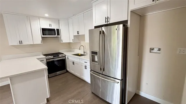 a kitchen with stainless steel appliances a refrigerator sink and microwave