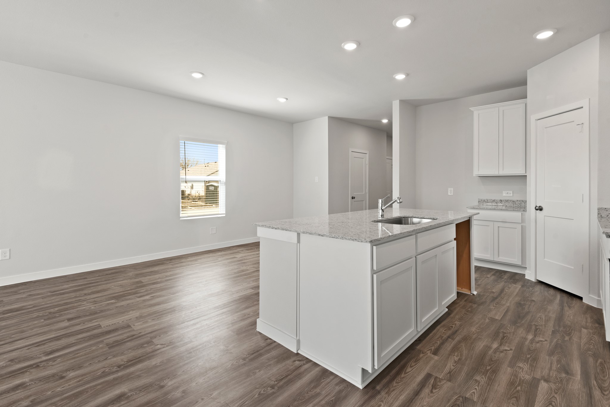 17211 King Eider Road Waller, TX 77484 - Photo 6 of 30 a kitchen with stainless steel appliances granite countertop a sink a stove a refrigerator and white cabinets with wooden floor