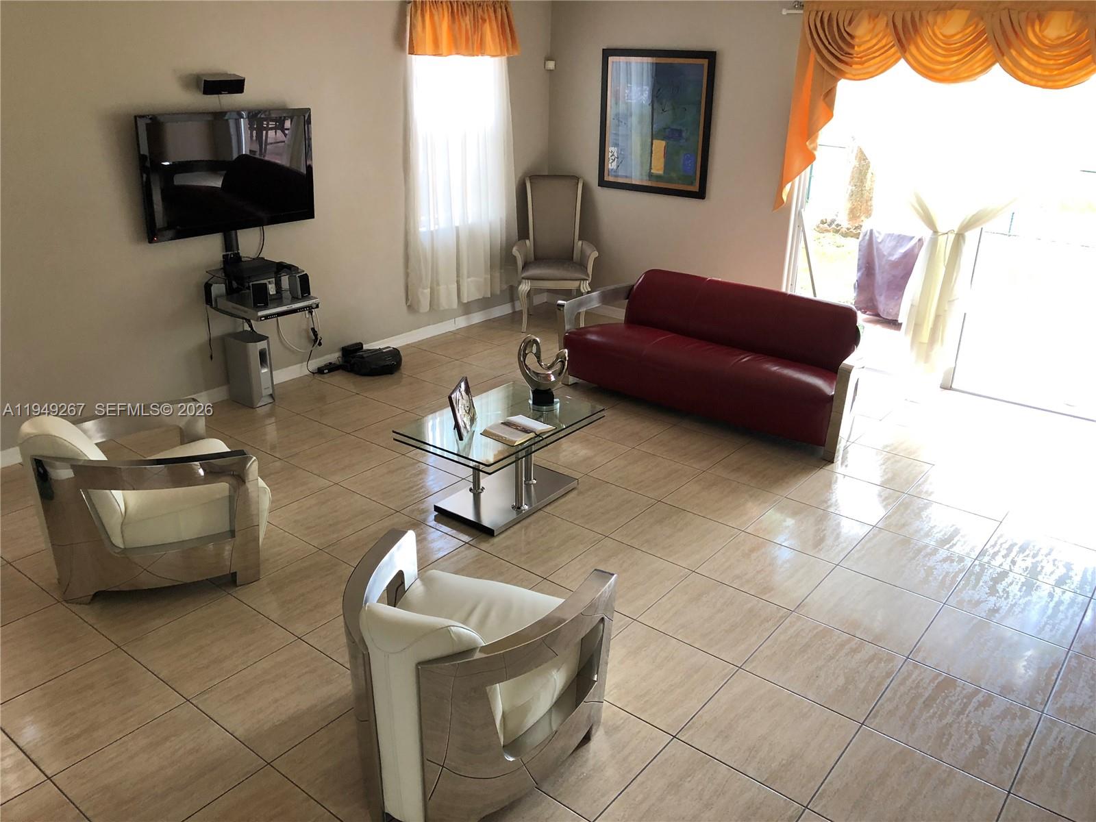 15364 Southwest 32nd Terrace Miami, FL 33185 - Photo 4 of 14 a living room with furniture a flat screen tv and a window