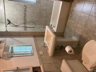 41 Woodbine Road East Hills, NY 11577 - Photo 12 of 15 Full bath with shower / tub combo, tile walls, wainscoting, and light tile patterned floors