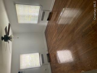 41 Woodbine Road East Hills, NY 11577 - Photo 13 of 15 Unfurnished room featuring radiator heating unit, dark wood-type flooring, and a ceiling fan