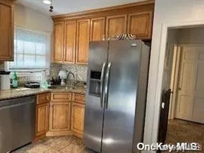 a kitchen with stainless steel appliances granite countertop a refrigerator a sink and white cabinets