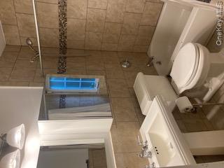 41 Woodbine Road East Hills, NY 11577 - Photo 10 of 15 Bathroom with tile walls, shower / bathtub combination with curtain, and tile patterned floors