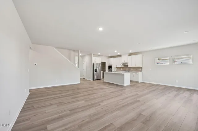 a view of empty room with wooden floor and window