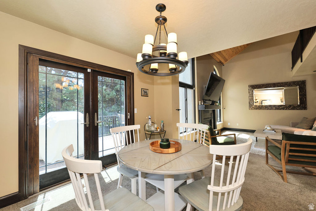 3104 East High Danish Road Sandy, UT 84093 - Photo 12 of 36 Dining area with a multi-tiered chandelier and wood-finish French doors opening to an exterior deck