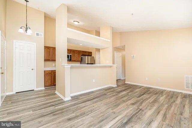 a view of a kitchen with wooden floor and a ceiling fan