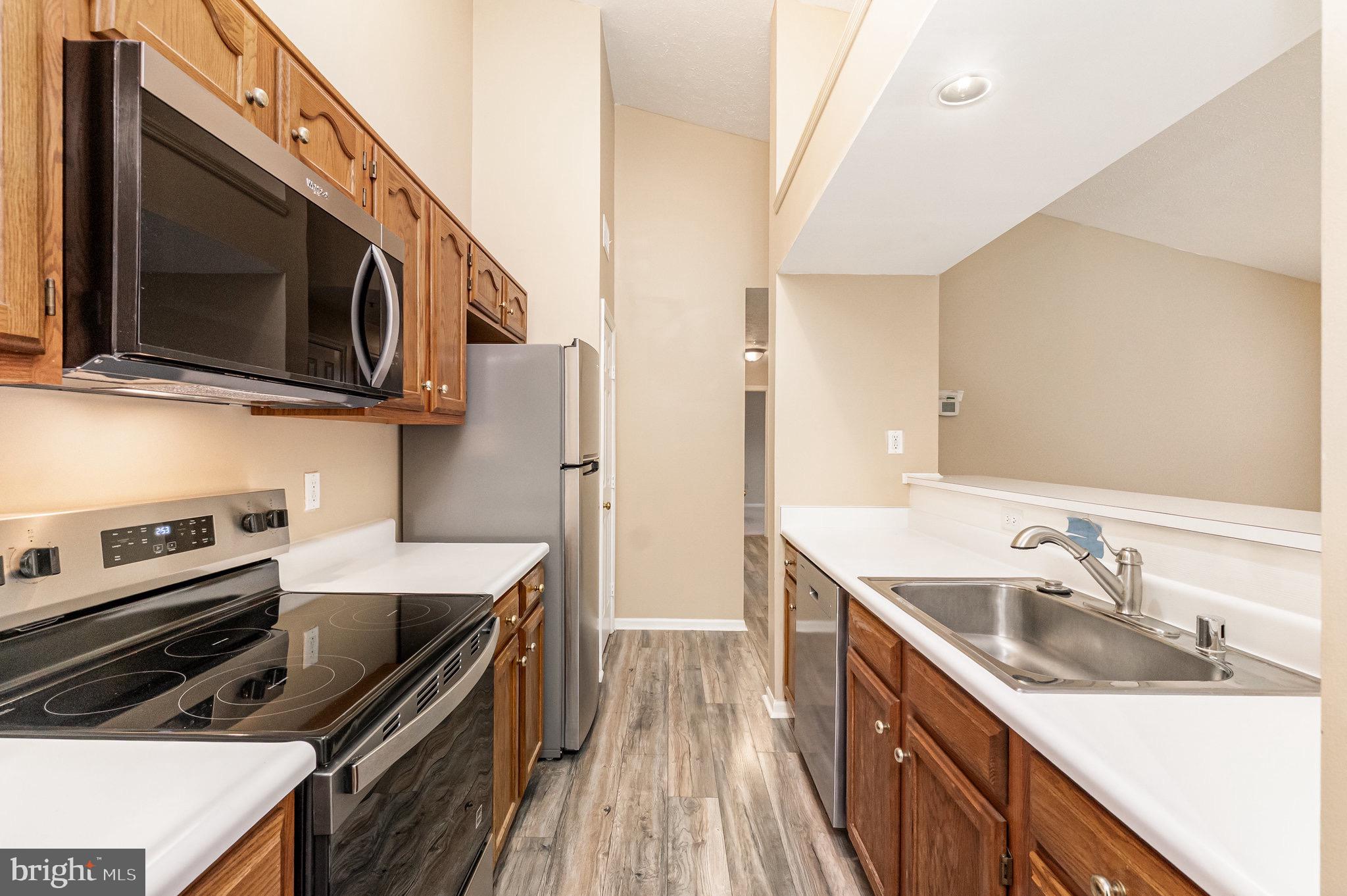 1401 Sage Lane, Unit 1401M Belcamp, MD 21017 - Photo 16 of 30 a kitchen with stainless steel appliances granite countertop a sink stove and microwave