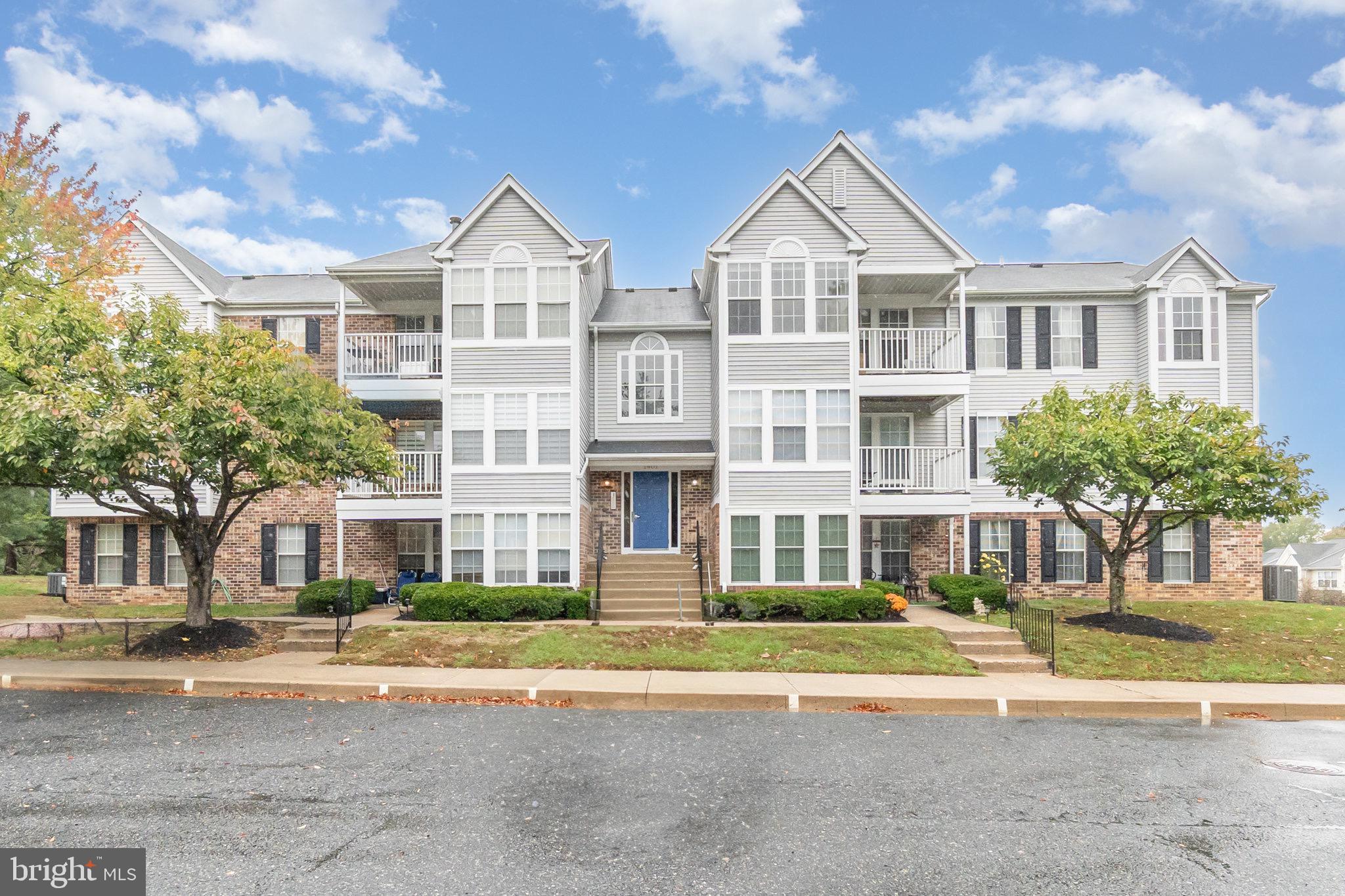 1401 Sage Lane, Unit 1401M Belcamp, MD 21017 - Photo 2 of 30 a view of a big house with a big yard and large trees