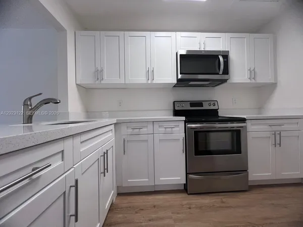 a kitchen with white cabinets and stainless steel appliances