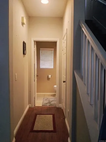a view of a hallway with a livingroom and a bathroom with sink