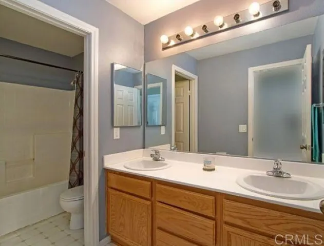 a bathroom with a double vanity sink toilet and shower
