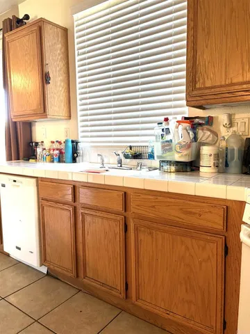 a kitchen with granite countertop white cabinets white appliances and sink