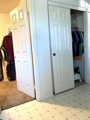 a view of walk in closet with clothes and shoes