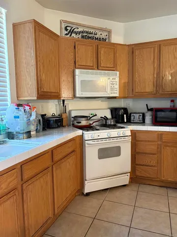 a kitchen with cabinets appliances a sink and a counter top