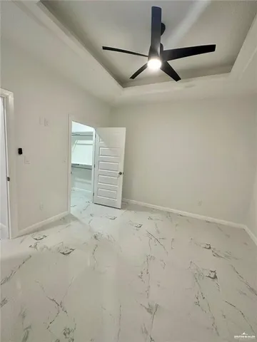 an empty room with chandelier fan