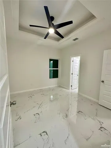 en empty room with a ceiling fan and window
