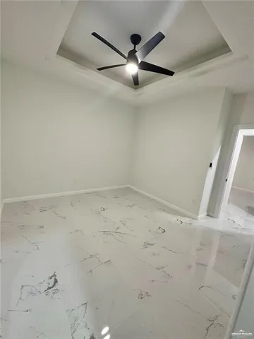 an empty room with a ceiling fan and window
