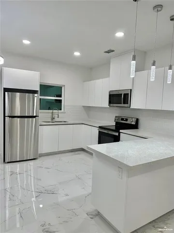 a kitchen with stainless steel appliances a refrigerator sink microwave and cabinets