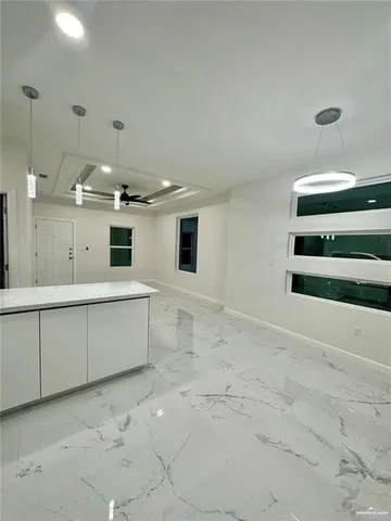 a large white kitchen with a sink and cabinets