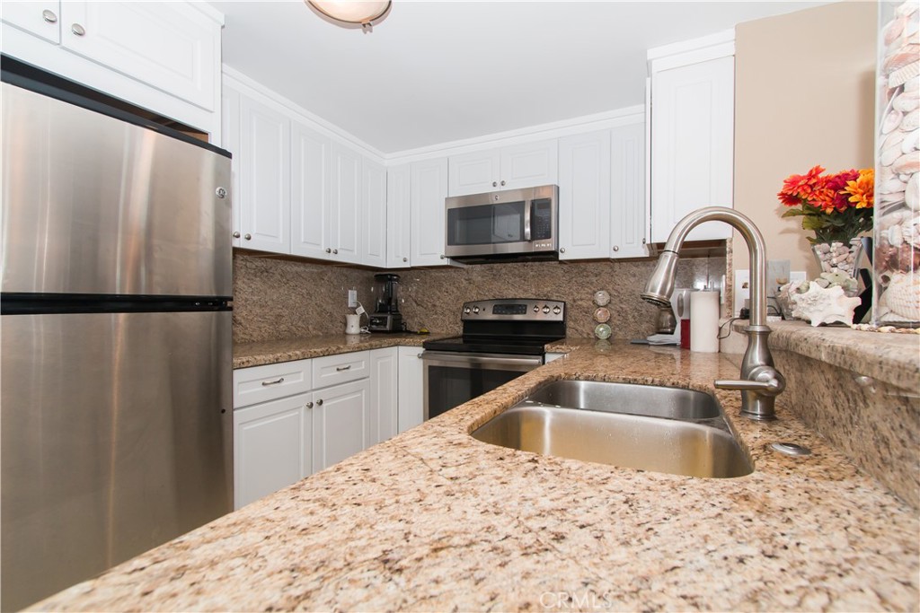 700 East Ocean Boulevard, Unit 706 Long Beach, CA 90802 - Photo 16 of 31 a kitchen with a sink a refrigerator and a microwave
