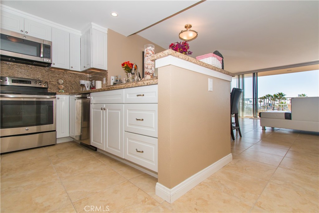 700 East Ocean Boulevard, Unit 706 Long Beach, CA 90802 - Photo 17 of 31 a kitchen with granite countertop a refrigerator and a stove
