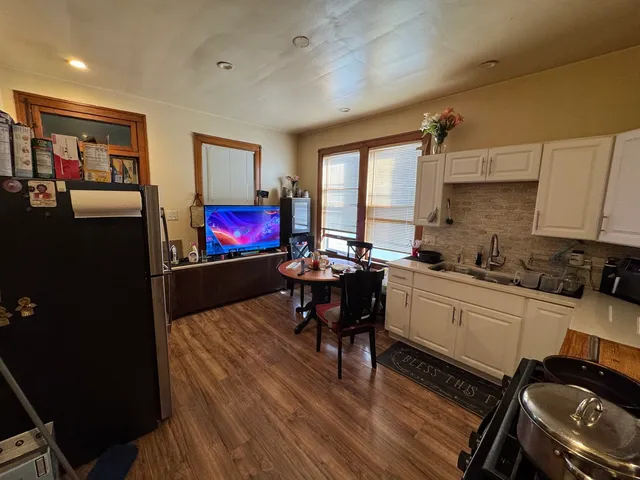 a kitchen with a dining table chairs and refrigerator