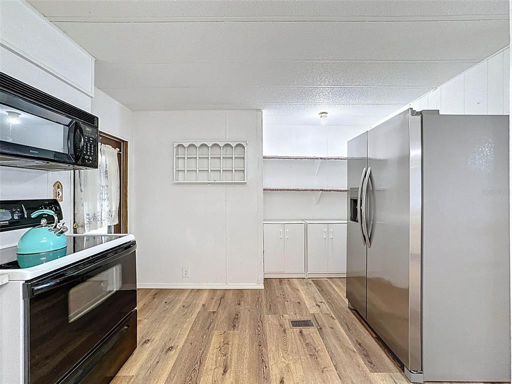3249 Susan Drive Spring Hill, FL 34606 - Photo 23 of 60 a kitchen with a refrigerator and a stove top oven