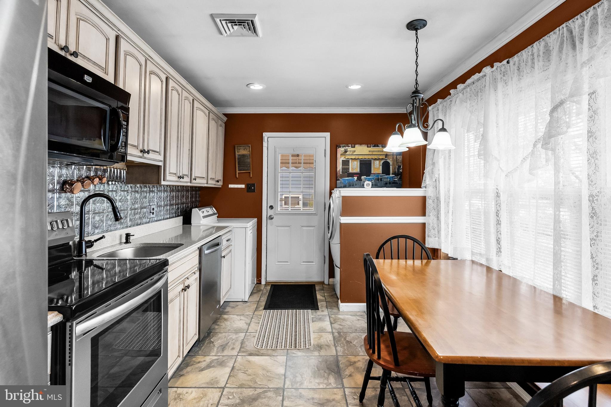 419 Delview Lane Delanco, NJ 08075 - Photo 5 of 21 a kitchen with stainless steel appliances granite countertop a refrigerator a sink dishwasher a stove and a dining table with wooden floor