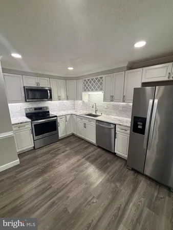 a kitchen with stainless steel appliances a refrigerator sink and microwave