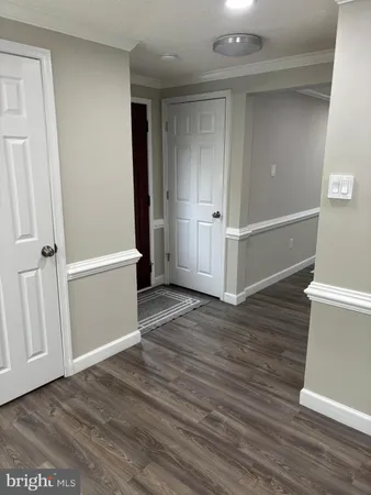 an empty room with wooden floor and white walls