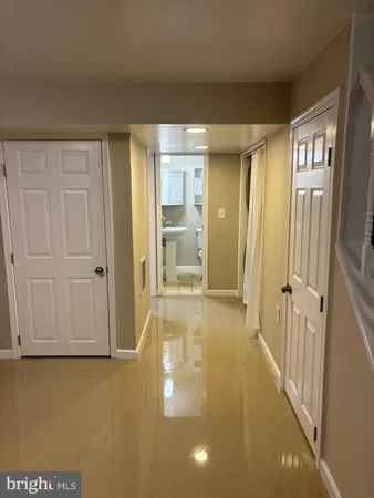 a view of a hallway with wooden floor and cabinet
